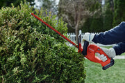Photo of CRAFTSMAN CMCHT810C1 hedge trimmer in use, cutting green bushes outdoors.
