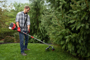 Photo of person using Craftsman gas string trimmer CMXGTAMDSS30 on grass near trees outdoors.